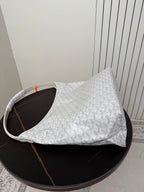 Goyard white hobo bag with monogram texture and curved top handles.