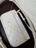 Goyard white zip pouch with monogram texture, leather trim, and front clasp.