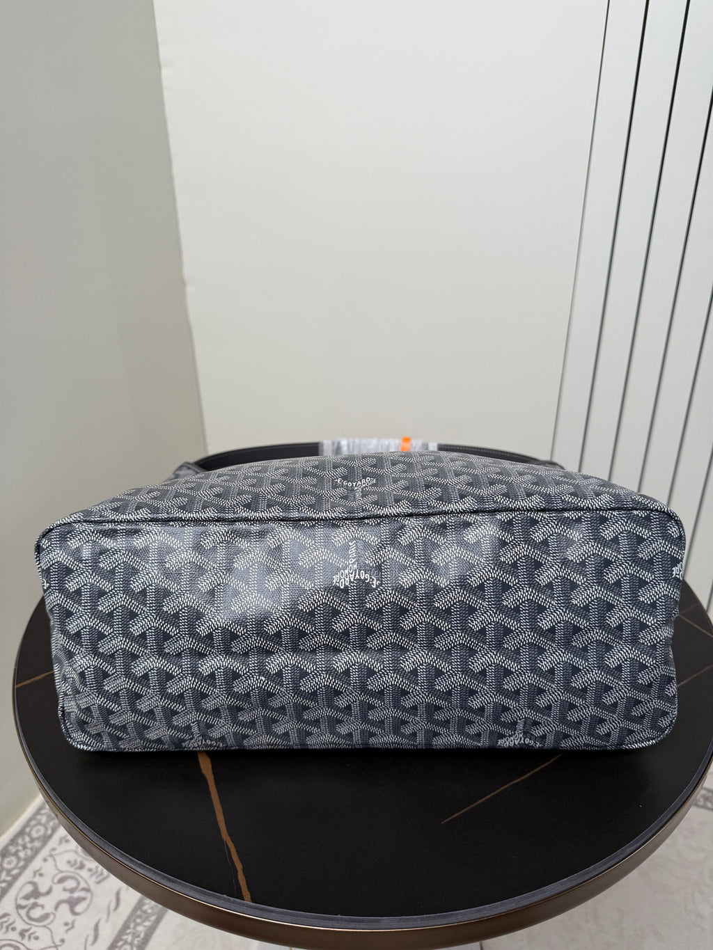 Goyard patterned hobo bag top view, blue-gray canvas with orange accent trim
