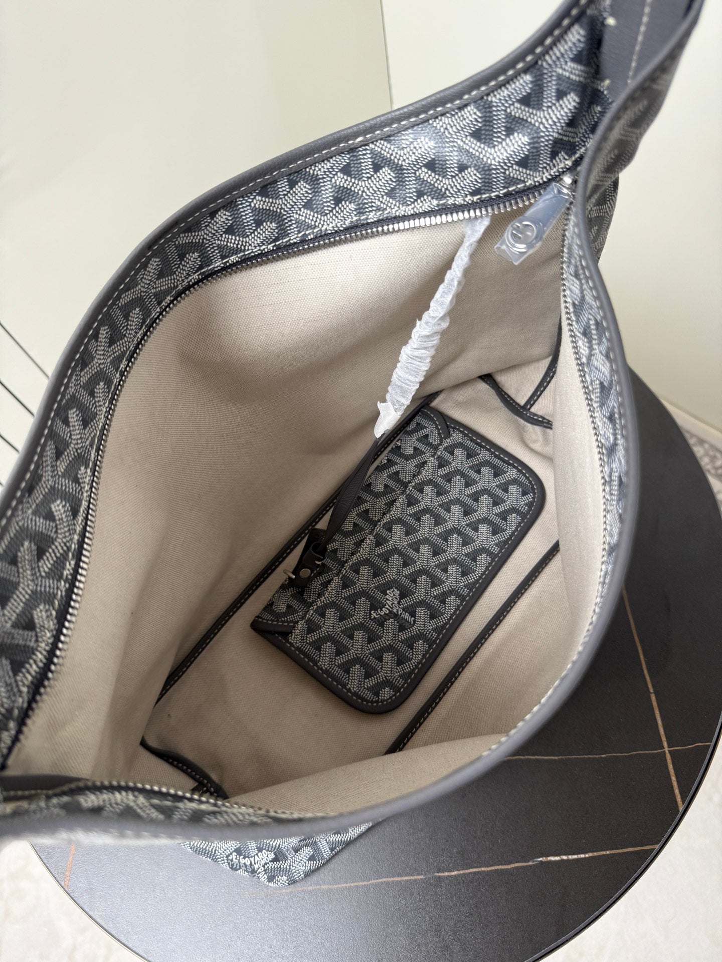 Goyard patterned hobo bag interior with beige lining and zip pocket