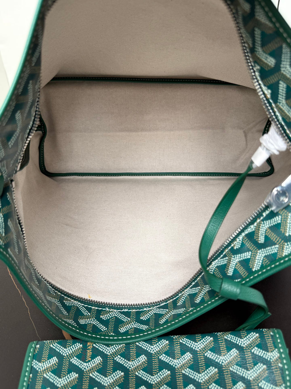 Goyard teal hobo bag interior with zipper top and stitched lining.