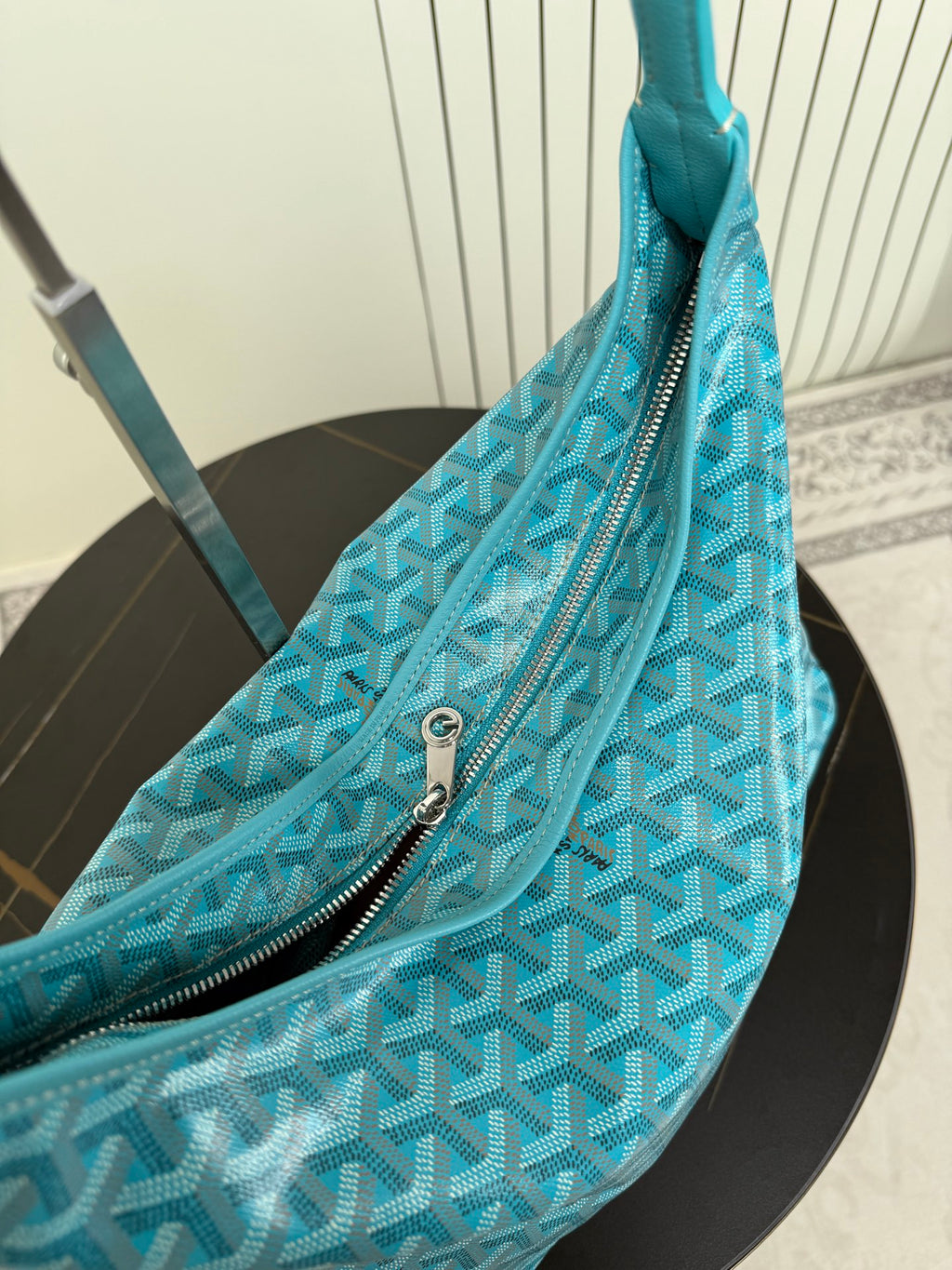 Goyard teal monogram bag with front zipper pocket and metal zipper pull