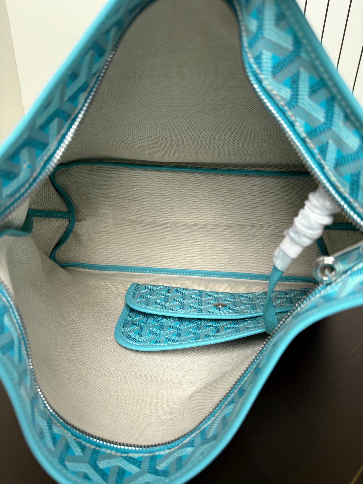 Goyard teal monogram hobo bag interior view with pocket and zipper edge