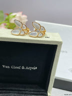 Gold-tone butterfly stud earrings with white mother-of-pearl petals on display box