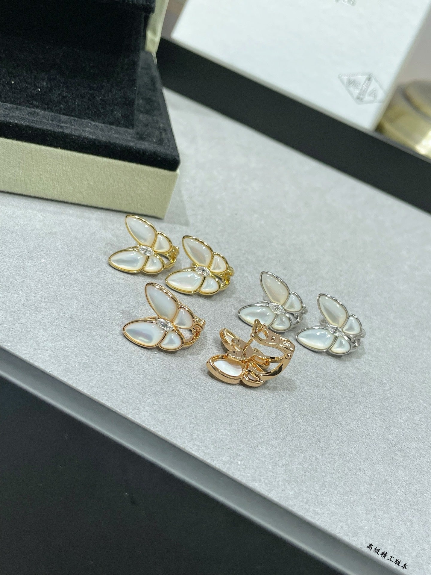 Assorted butterfly stud earrings with white mother-of-pearl petals in gold-tone settings