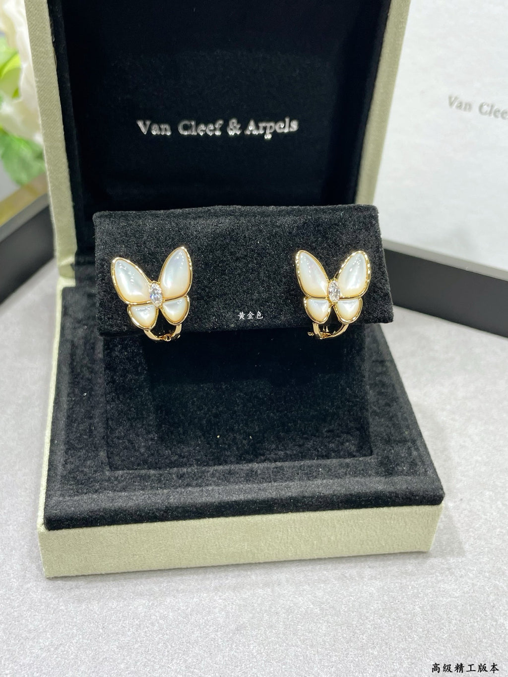 Butterfly stud earrings with white mother-of-pearl petals on gold-tone settings in box