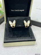 Butterfly stud earrings with white mother-of-pearl petals on gold-tone settings in box