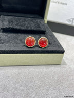 Van Cleef & Arpels earrings, gold-tone studs with red round stones on display