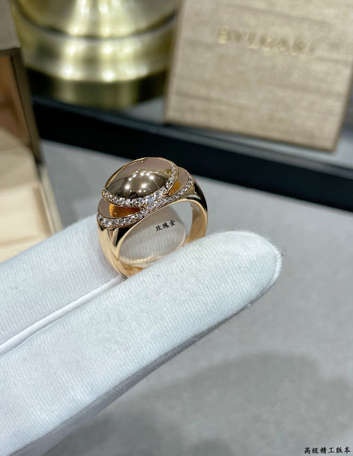 Gold-tone ring with oval center stone and pavé diamond-look wrap band