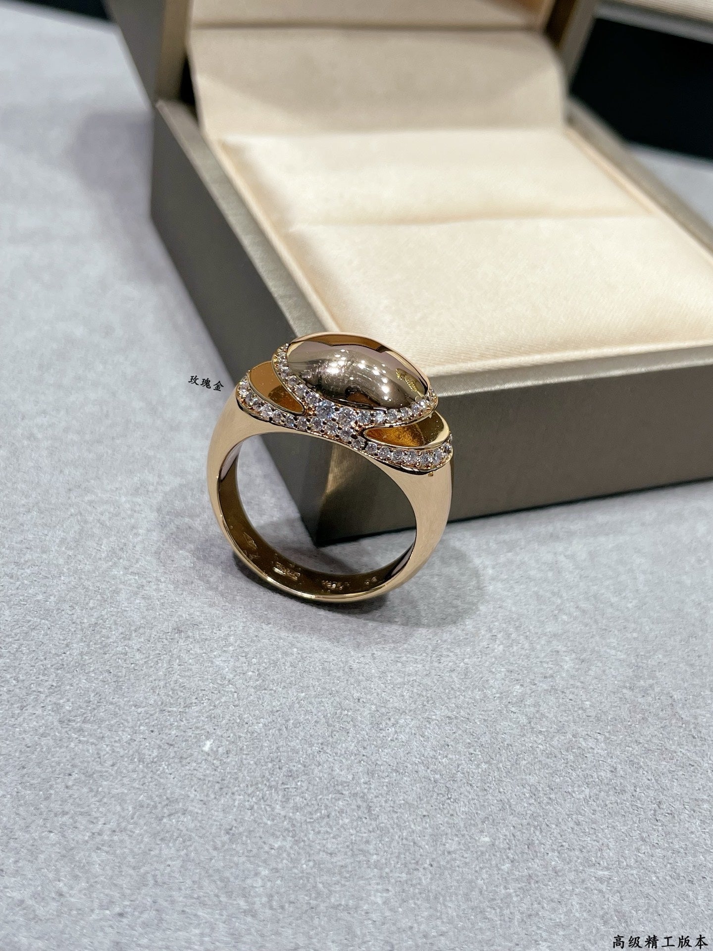 Gold-tone ring with oval center stone and pavé diamond-look band on display
