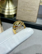 Gold-tone ring with large oval center stone and pavé diamond-look band
