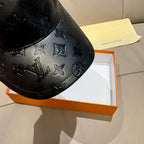 Louis Vuitton monogram cap detail, black embossed leather with repeating icons
