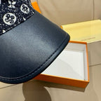 Louis Vuitton baseball cap brim close-up, navy leather with visible edge stitching.