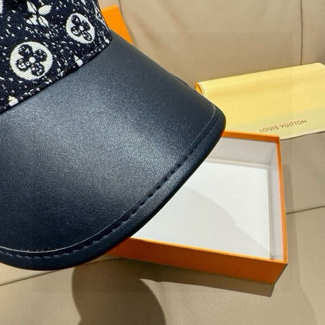 Louis Vuitton baseball cap brim close-up, navy leather with visible edge stitching.