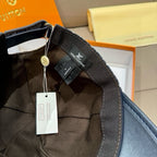 Louis Vuitton baseball cap underside close-up with black fabric strap and hanging tags.