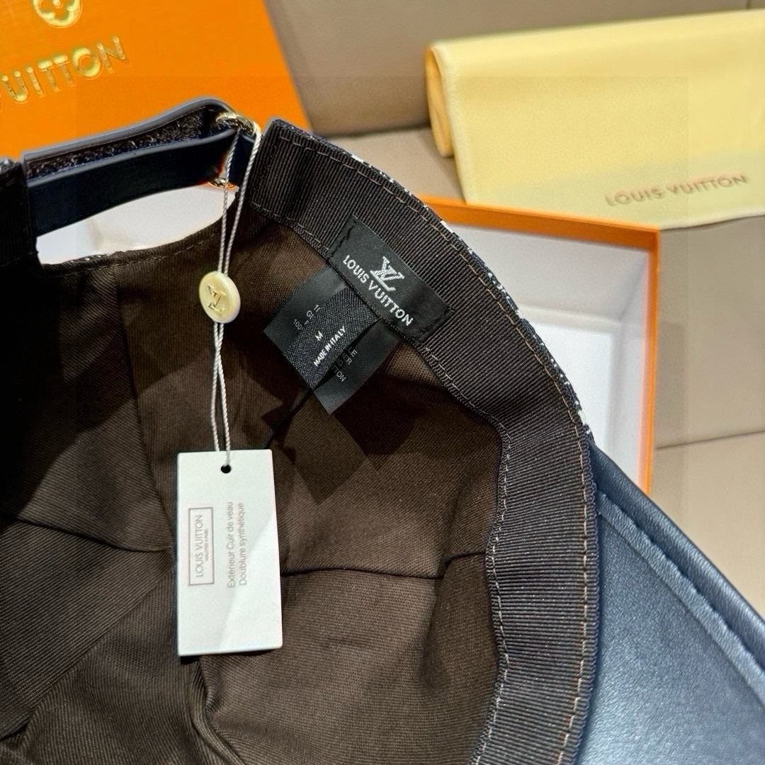 Louis Vuitton baseball cap underside close-up with black fabric strap and hanging tags.