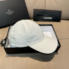 White baseball cap on box with curved brim and stitched crown seams.
