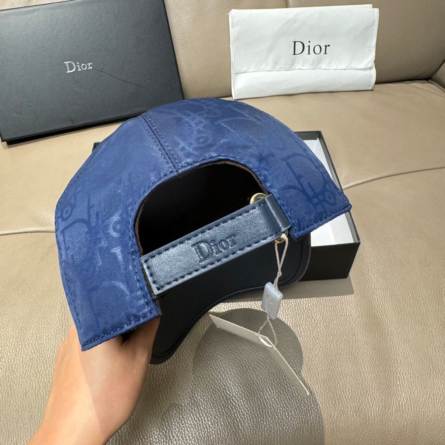 Blue Dior cap with black adjustable band and open interior brim.