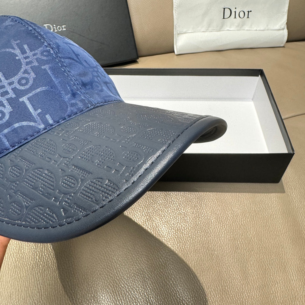 Blue Dior cap brim detail with repeating monogram texture.