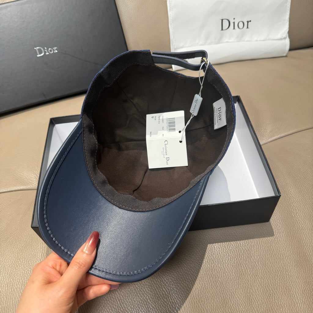 Blue Dior baseball cap interior with adjustable strap and hanging tags.