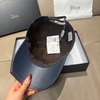 Blue Dior baseball cap interior with adjustable strap and hanging tags.