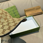Gucci baseball cap with brown GG monogram fabric and black inner trim at the brim.