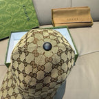 Gucci baseball cap top view with brown GG monogram fabric and round button.