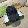 Black Gucci monogram baseball cap with curved brim and small gold emblem