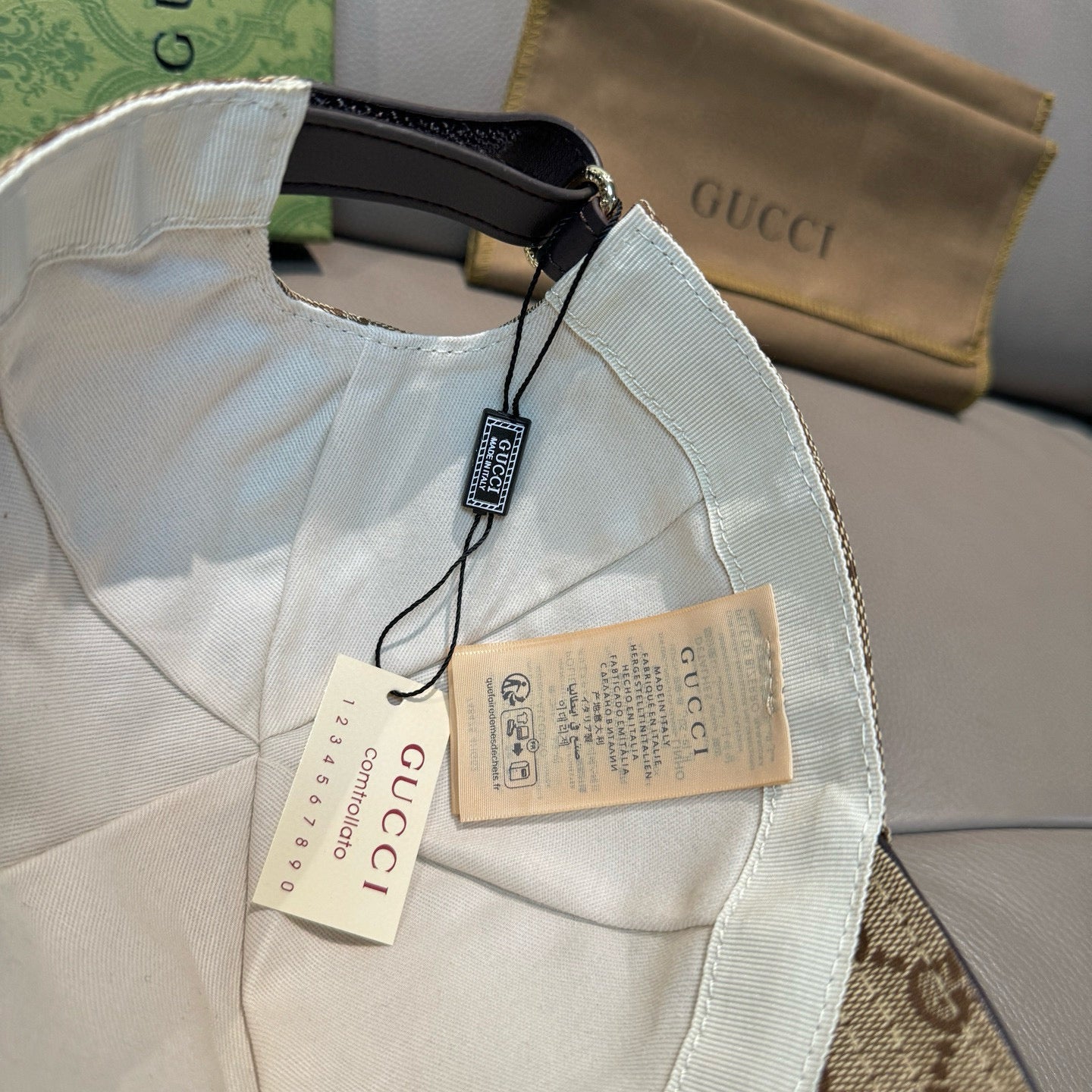 Gucci baseball cap in white with black strap and hanging tags on the inside
