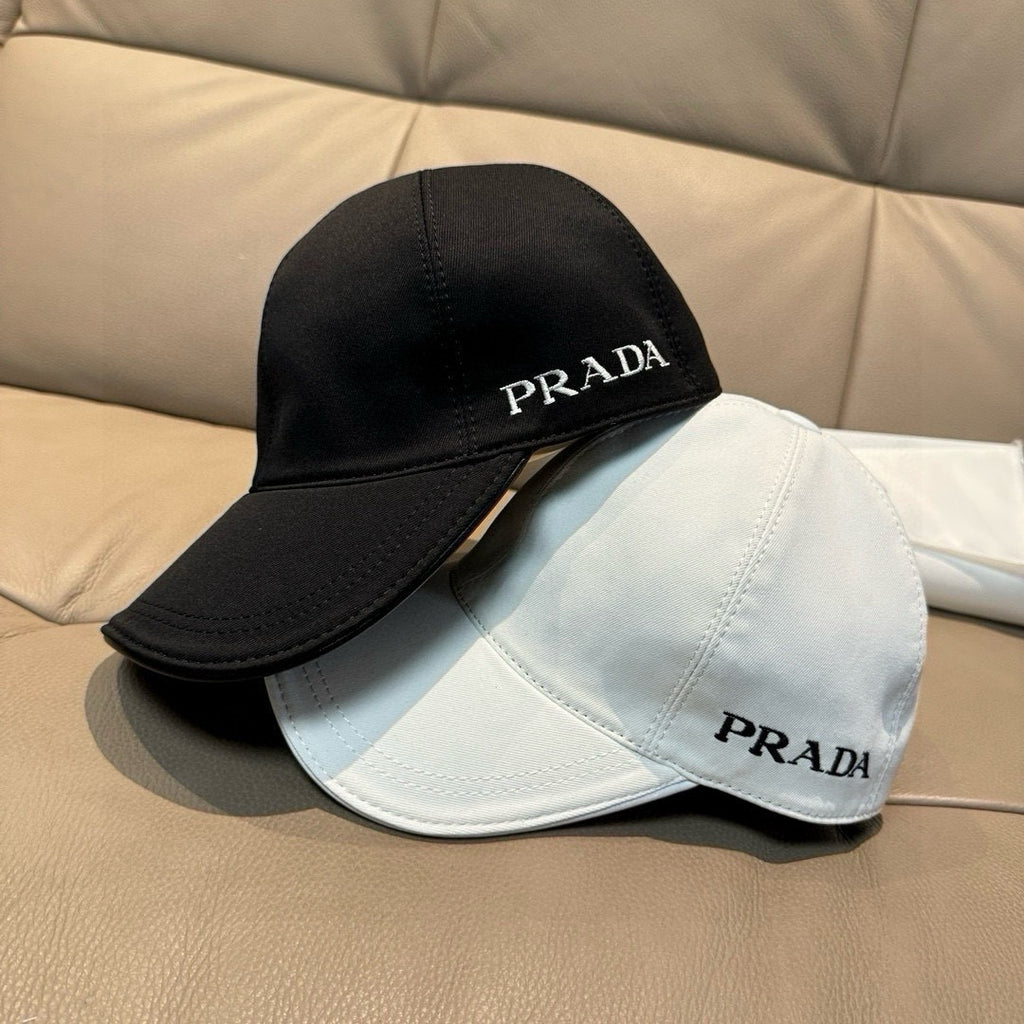 Black and white Prada baseball caps, each with embroidered PRADA logos