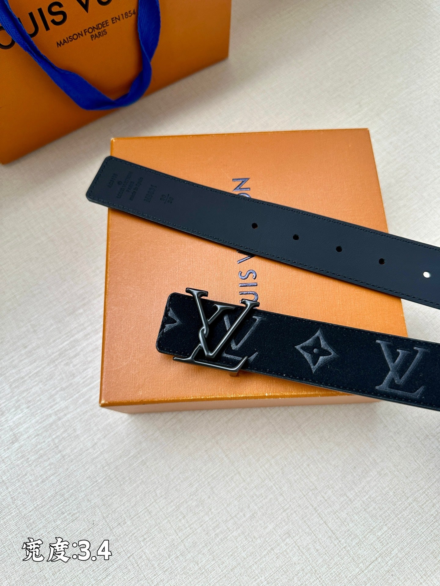 Dark blue belt with monogram pattern, square buckle and multiple holes