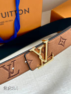 Close-up monogram belt with gold-tone V buckle and rectangular leather keeper on tan strap