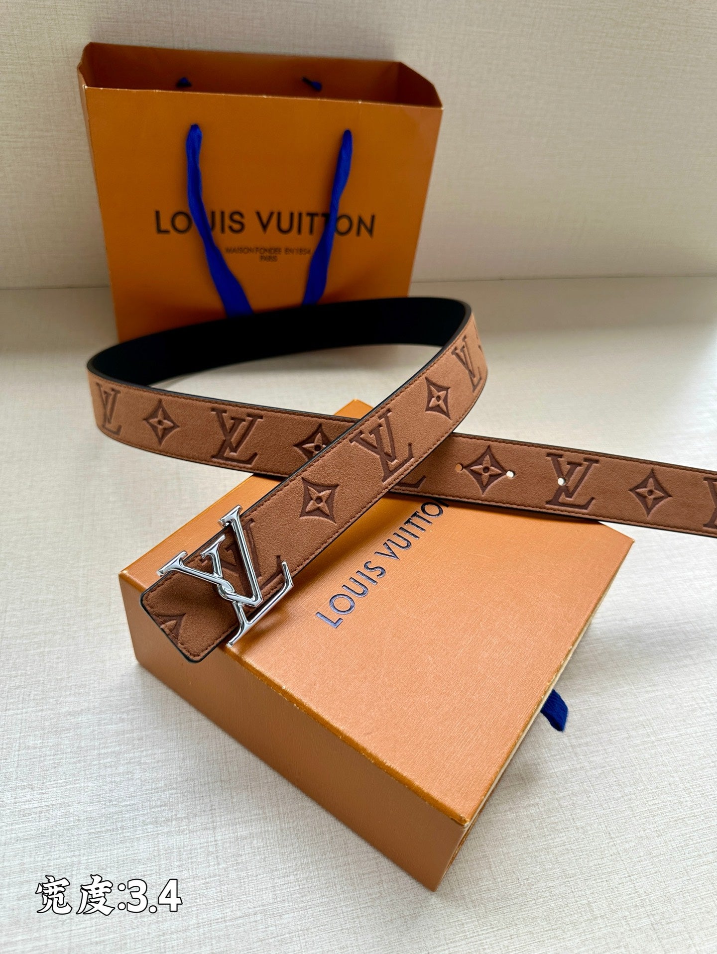 Tan/brown monogram belt with gold-tone V buckle and dark interior lining