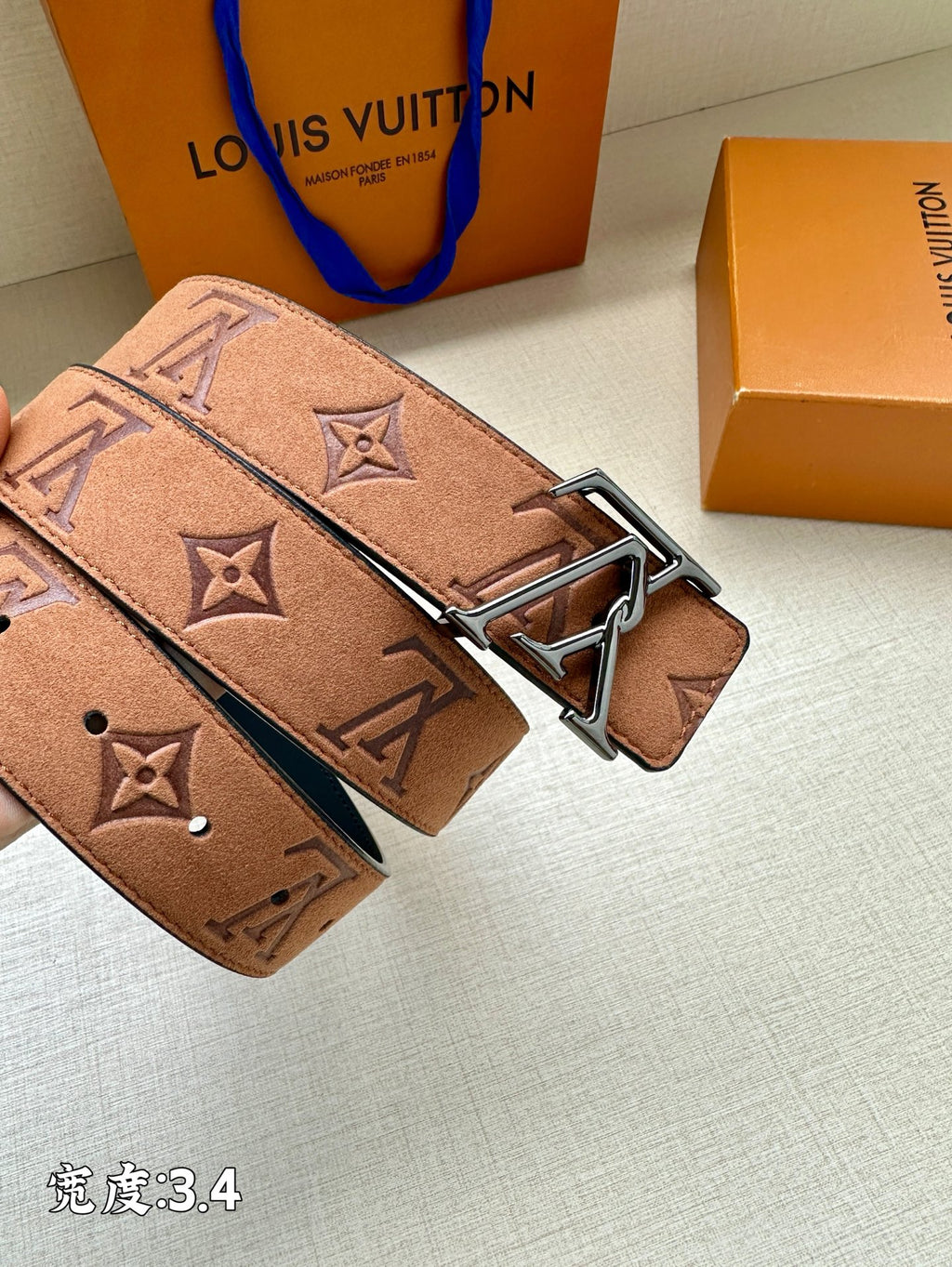 Monogram leather belt with silver-tone buckle, tan/brown strap with dark stitched edges