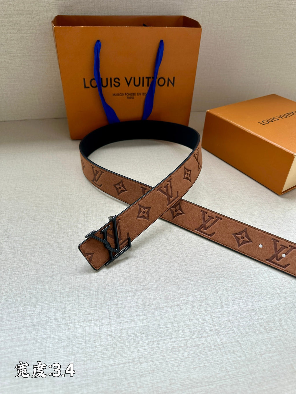 Louis Vuitton belt with brown monogram pattern and dark metal buckle