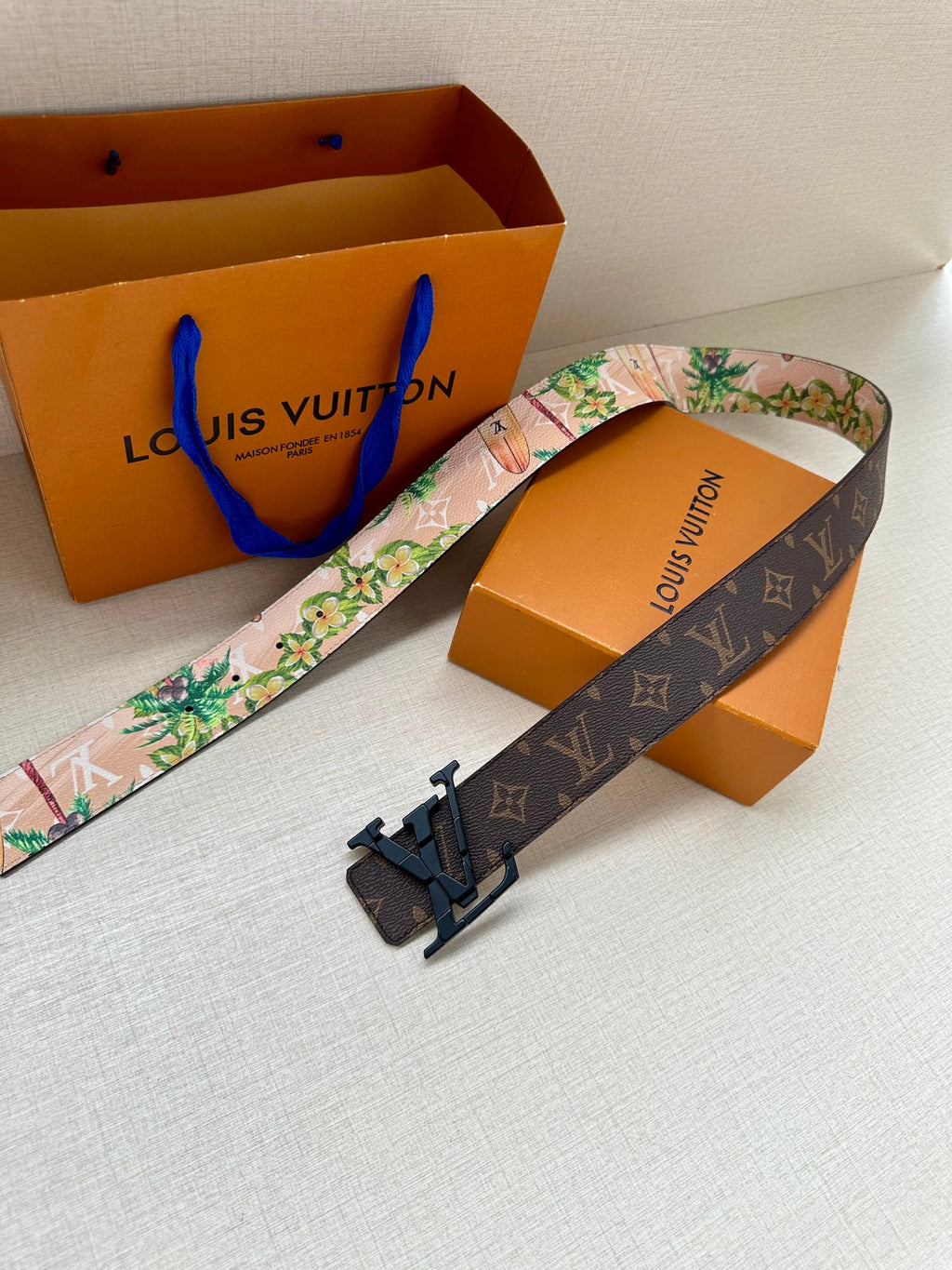 Reversible belt with monogram exterior, floral inner, and black LV buckle