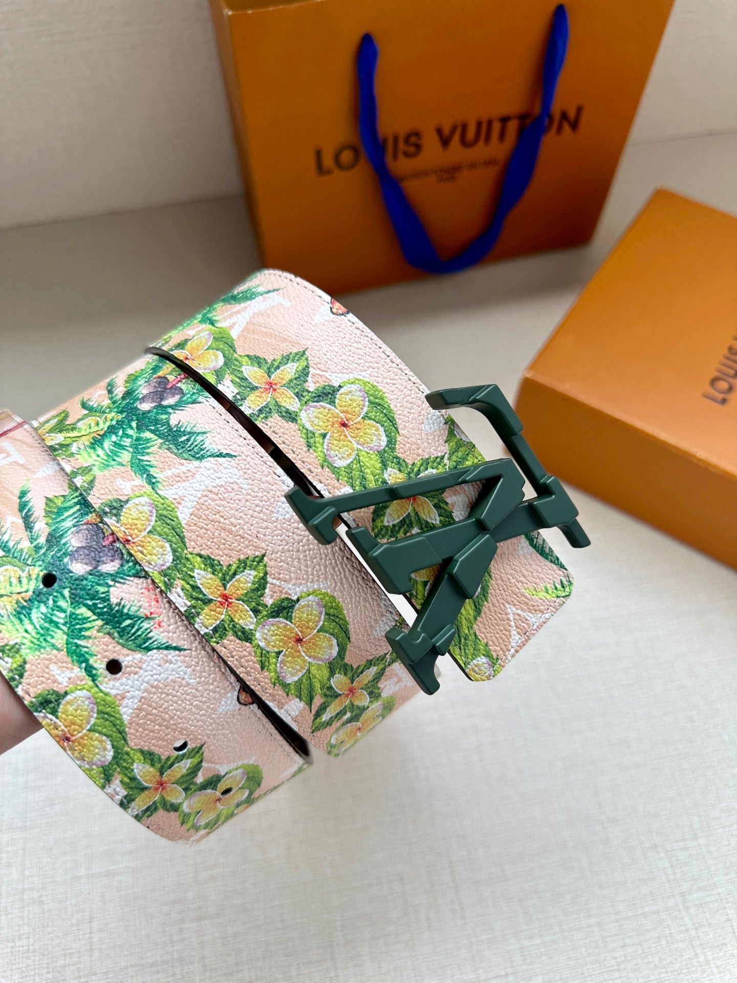 Louis Vuitton belt with floral strap and green LV buckle, dark leather edge
