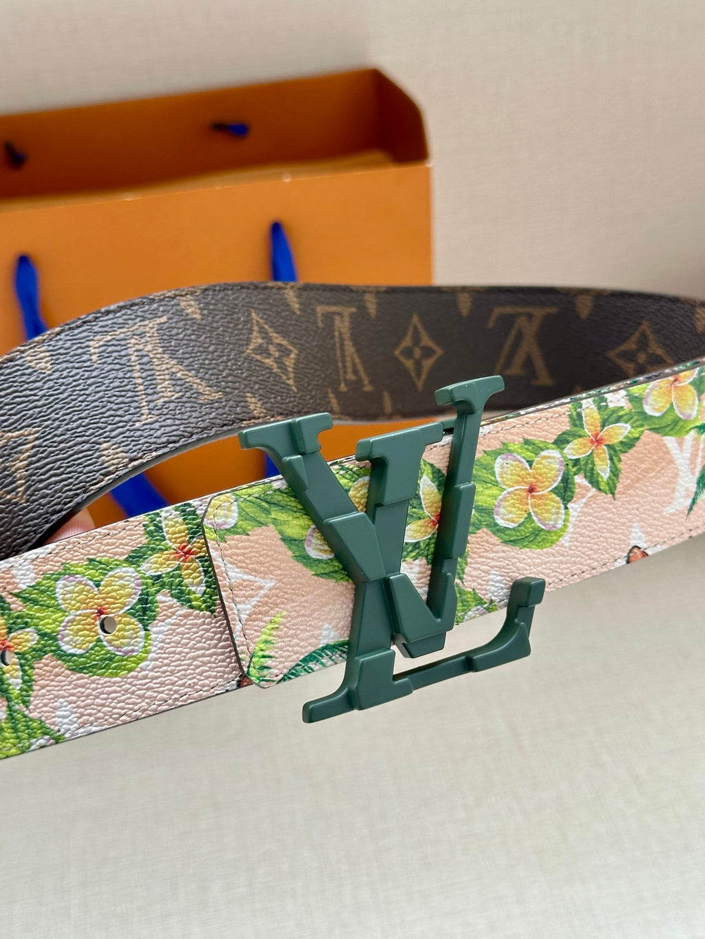 Louis Vuitton belt buckle detail on floral strap with dark monogram border