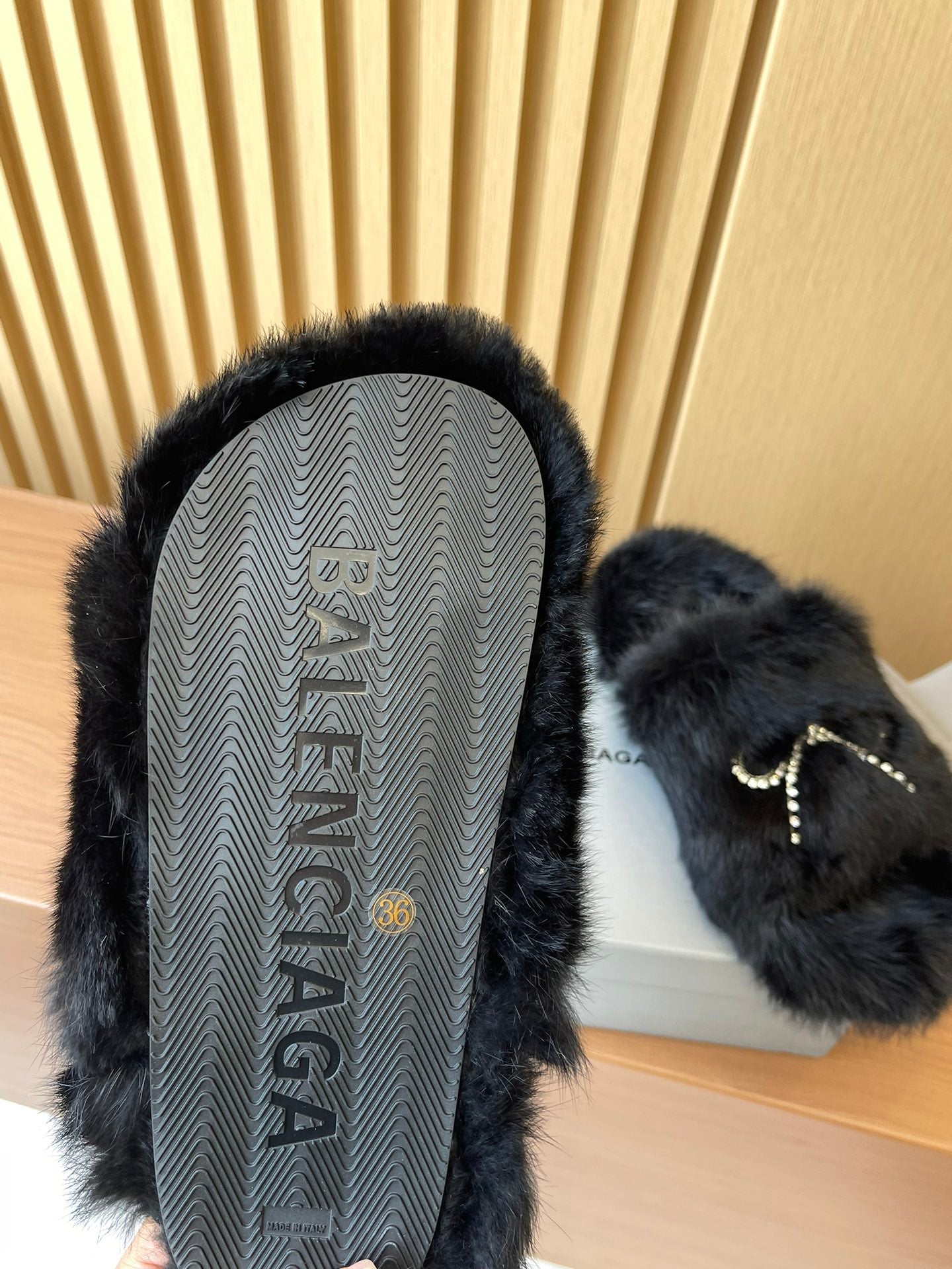 Balenciaga fuzzy sandal with textured outsole visible and dark fur upper