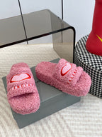 Pink fuzzy slide sandals with red heart logo, pair on box