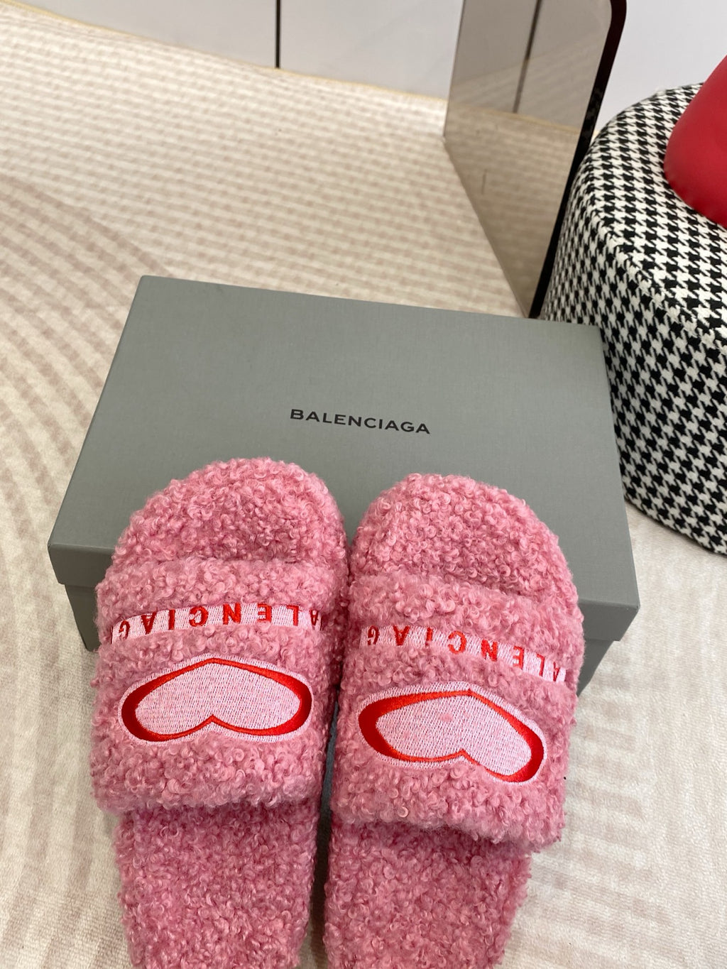 Pink fuzzy slides on box with red heart logo and BALENCIAGA lettering