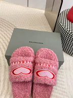 Pink fuzzy slides on box with red heart logo and BALENCIAGA lettering