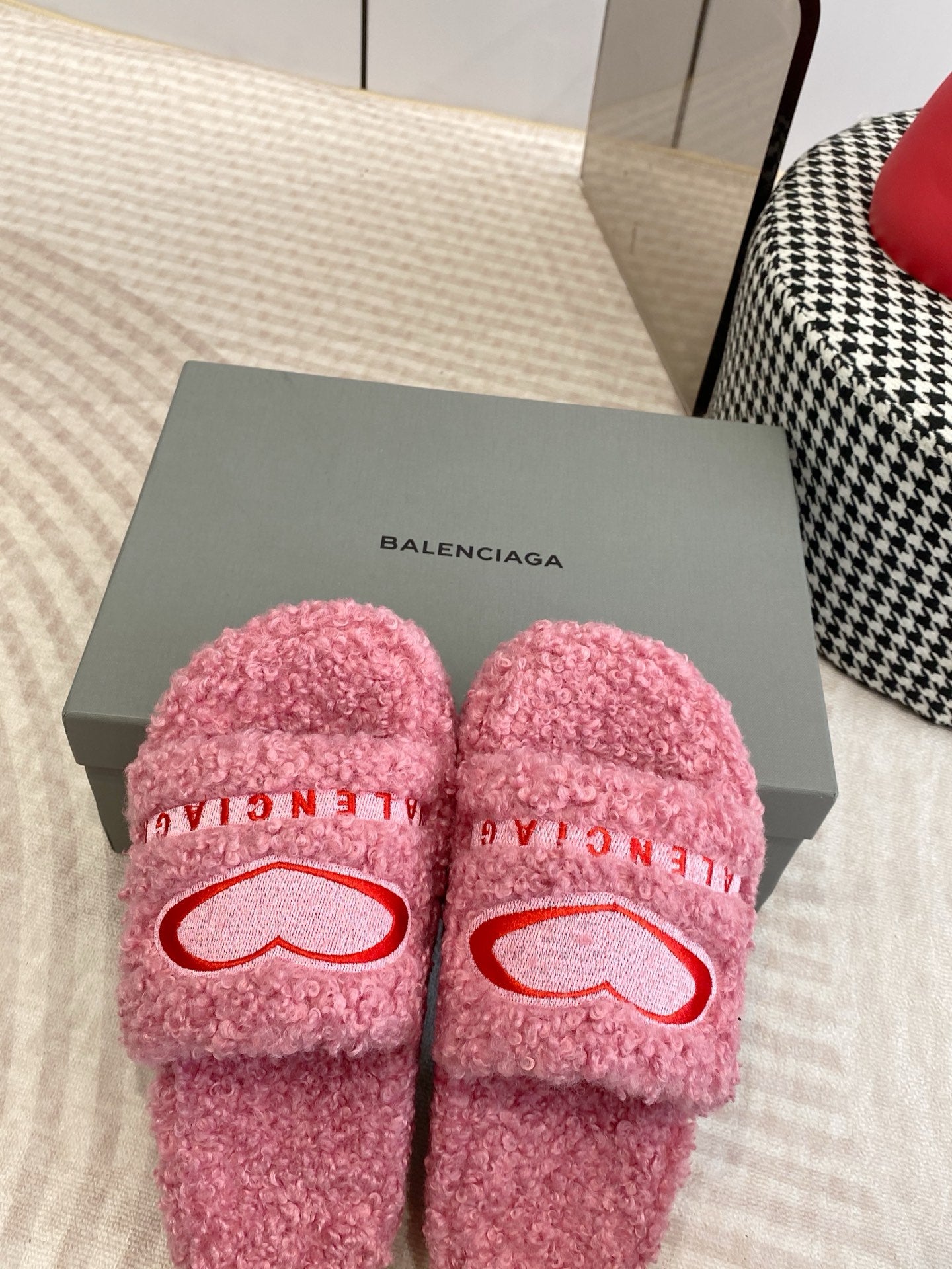 Pink fuzzy slides on box with red heart logo and BALENCIAGA lettering