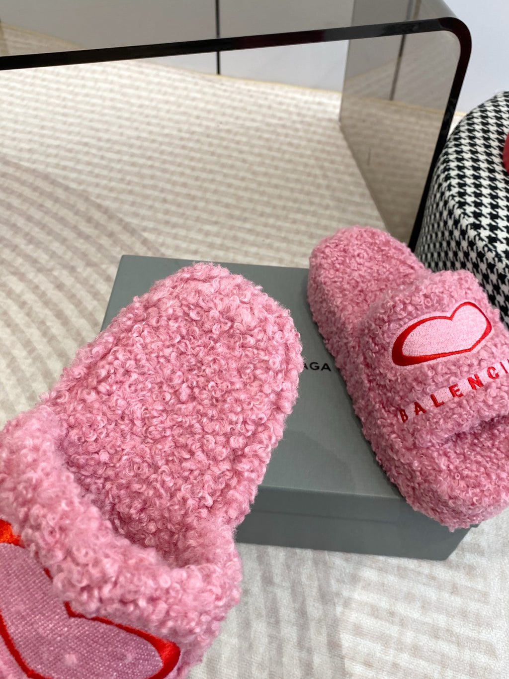 Pink fuzzy open-toe slides with red heart logo on strap