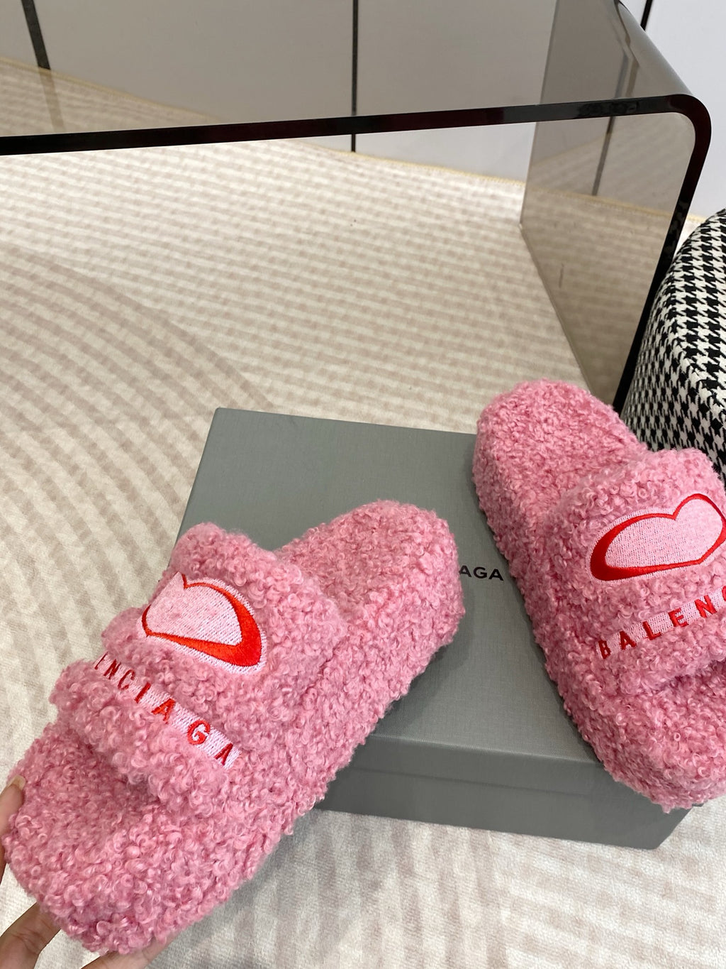 Pink fuzzy slide sandals with red heart emblem on front strap