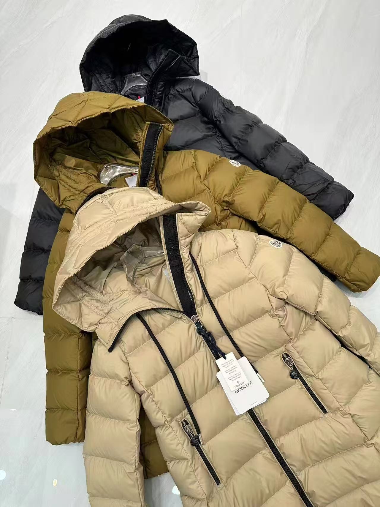 Long puffer coats, black, olive and light cream, hooded with zip fronts