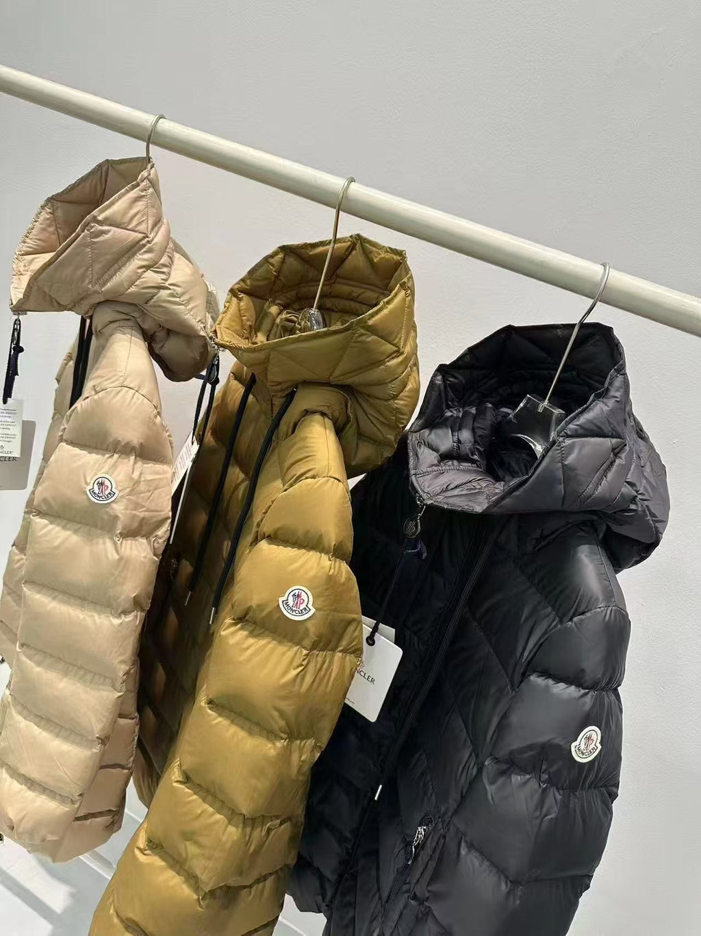 Long puffer coats, light beige, olive and dark, hooded with zip fronts