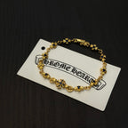 Gold charm bracelet with blue flower beads on a white product tag.