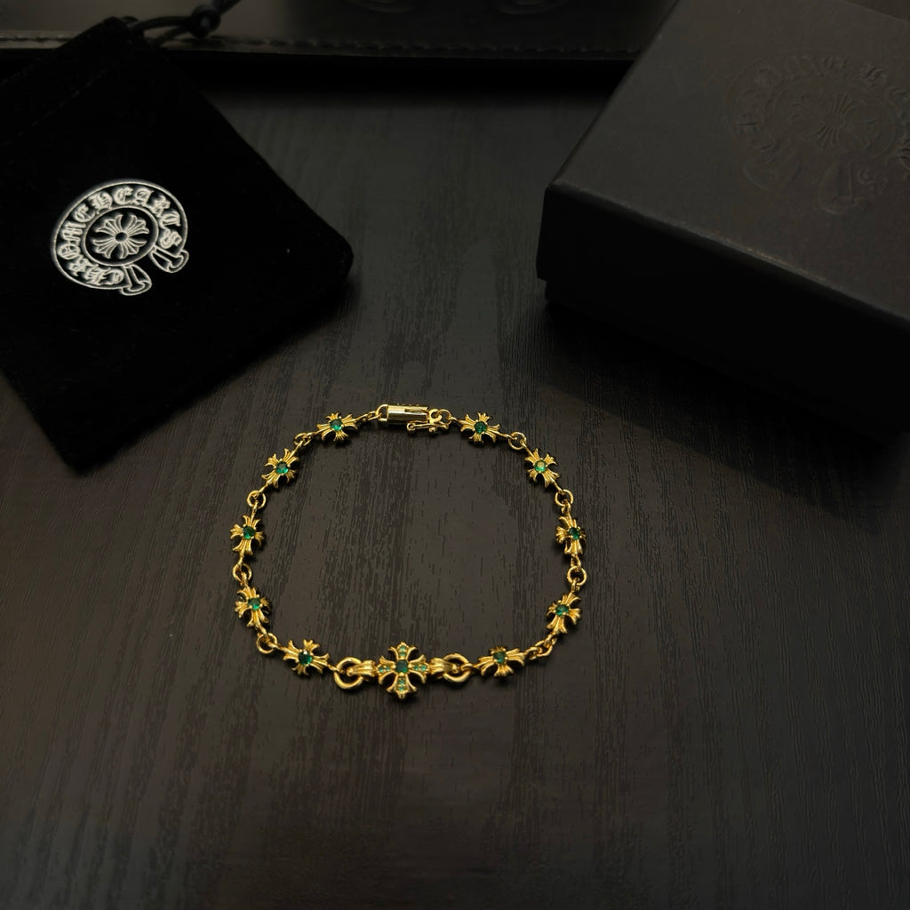 Gold-tone link bracelet with green flower charms, displayed on dark surface