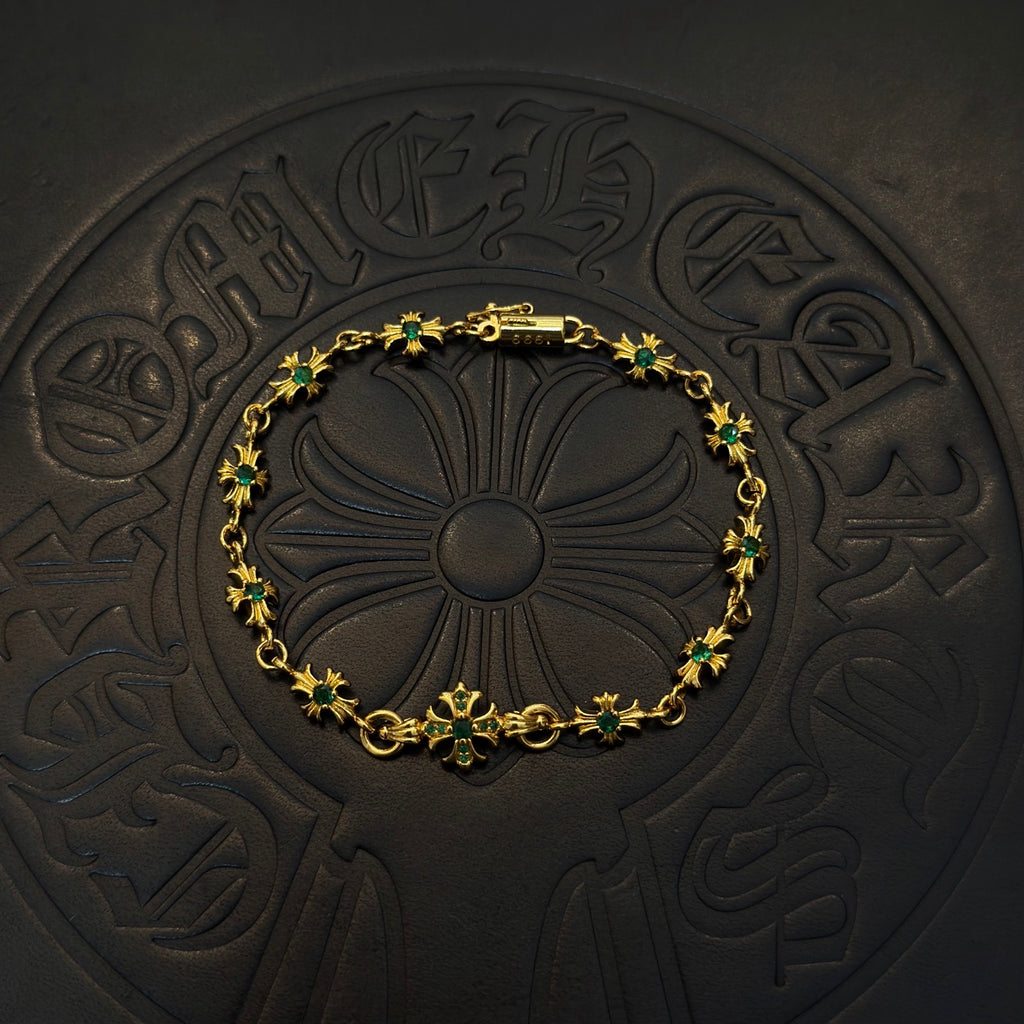 Gold-tone link bracelet with green flower charms and centered floral motif